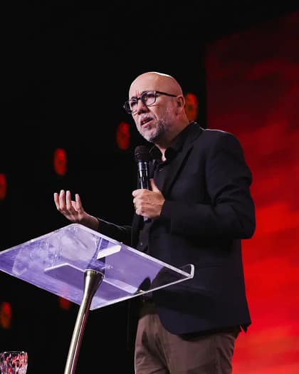 Pastor Carlo Ribas pregando com o microfone na mão